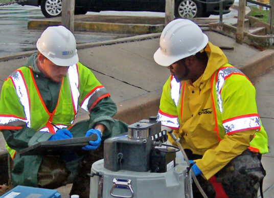 Two KCI employees perform stormwater quality monitoring